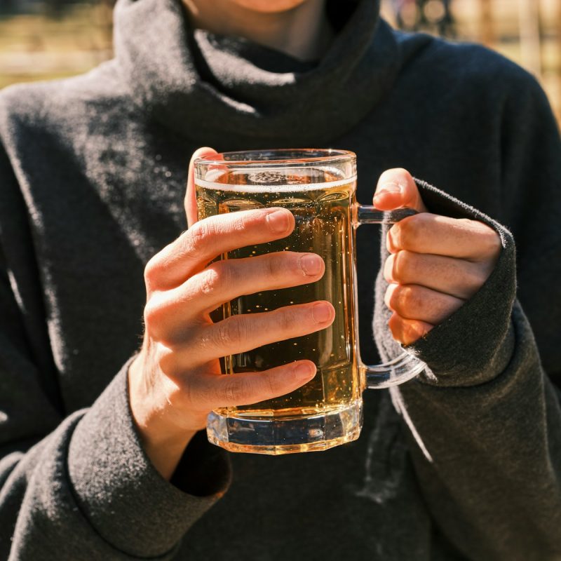 a woman holding a glass of beer in her hands